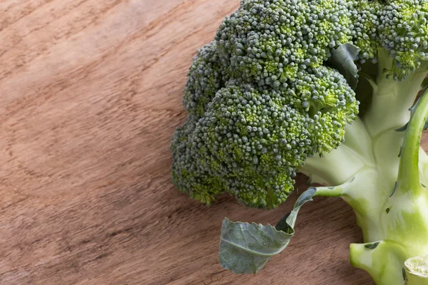 Organické rostlinné zelené brokolice na dřevěné desce připravené, vaření — Stock fotografie