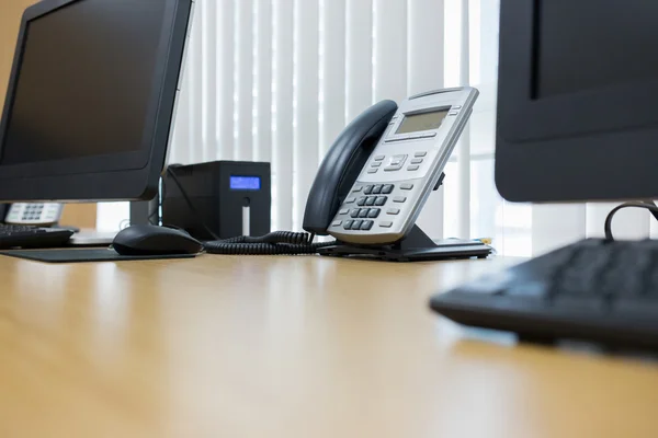 Telefono e computer sul tavolo lavoro dell'ufficio del servizio in camera — Foto Stock