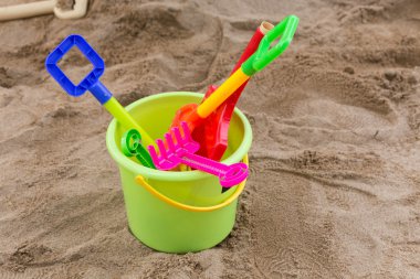 Çocuğun oyuncaklar oynamak için kova kum ve oyun alanında kürek