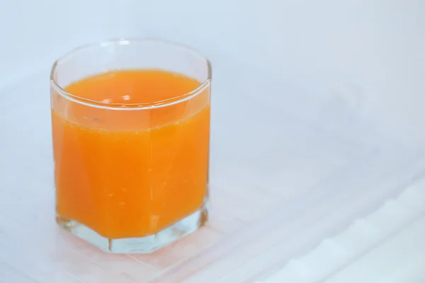 Glass of fresh orange juice in refrigerator — Stock Photo, Image