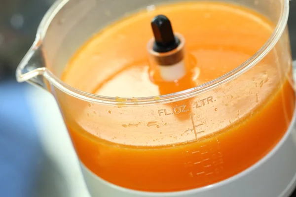 Fruta laranja espremida com a mão da mulher na máquina do juicer — Fotografia de Stock