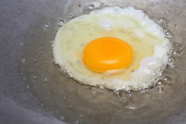 Cocinar huevo frito en sartén caliente con aceite — Foto de Stock