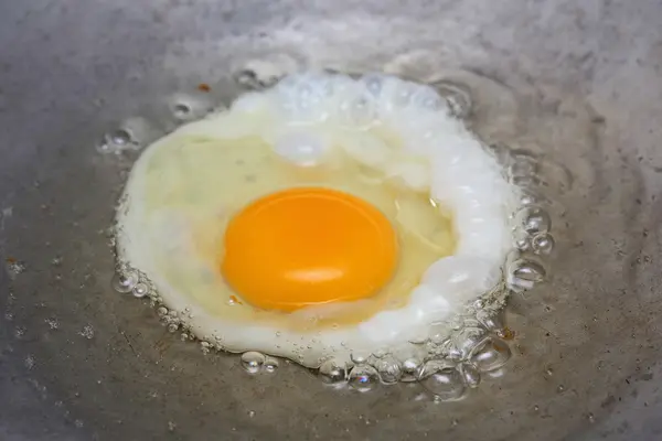 Cocinar huevo frito en sartén caliente con aceite — Foto de Stock