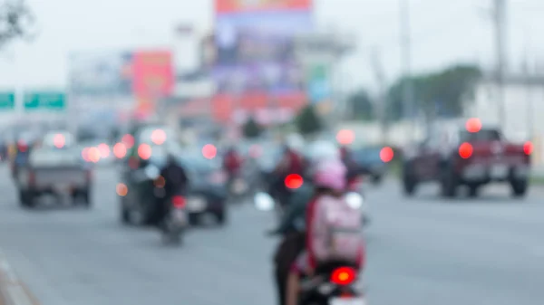 Car and motorcycle driving on road with traffic jam in the city