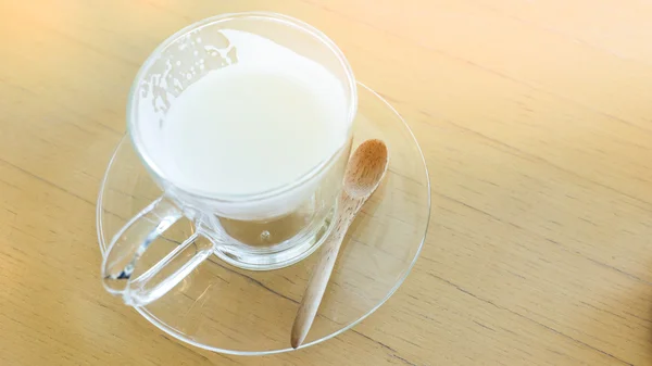 Bebida caliente leche con cuchara en la mesa de madera —  Fotos de Stock