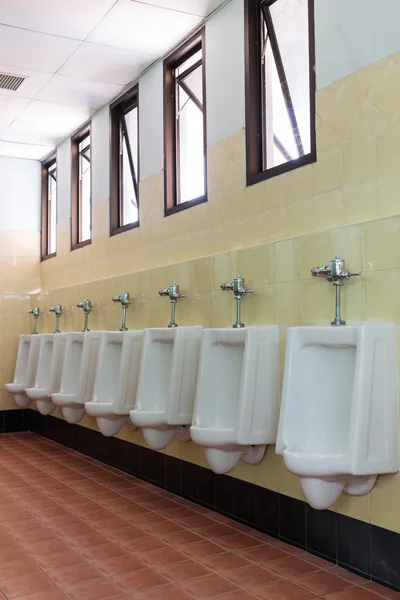 Rij witte urinoirs in mannen badkamer toilet — Stockfoto