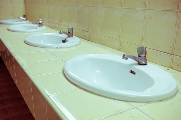 Beyaz yıkama lavabo eski gümüş musluk ile banyoda — Stok fotoğraf