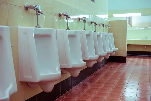 Белые писсуары в мужском туалете — стоковое фото
