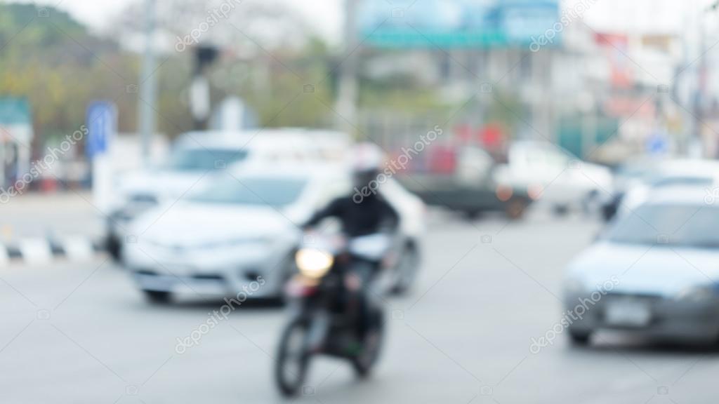 car and motorcycle driving on road with traffic jam in the city