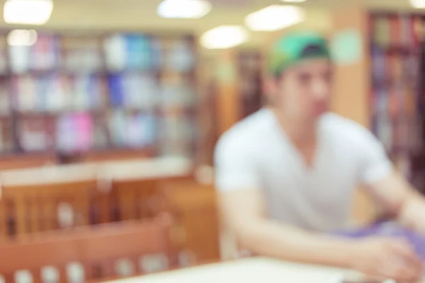 Bibliothek verschwimmt Hintergrund mit Student und Bücherregal — Stockfoto