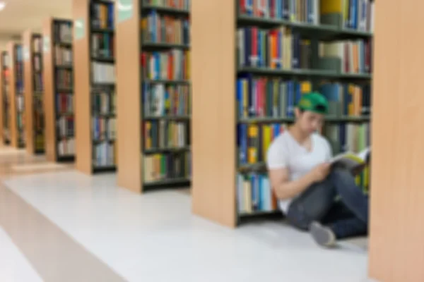Bibliothek verschwimmt Hintergrund mit Student und Bücherregal — Stockfoto