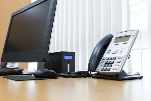 Τηλέφωνο και τον υπολογιστή στο τραπέζι εργασίας του γραφείου υπηρεσία δωματίου — Φωτογραφία Αρχείου