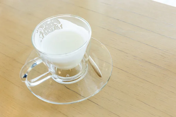 Hot drink milk with spoon on wood table — Stock Photo, Image