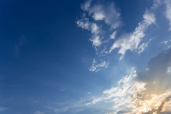 Mot bakgrund av sunbeam på blå himmel bakgrund med moln och solljus — Stockfoto