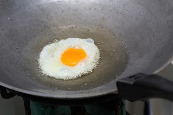 Cooking fried egg in hot pan with oil — Stock Photo, Image