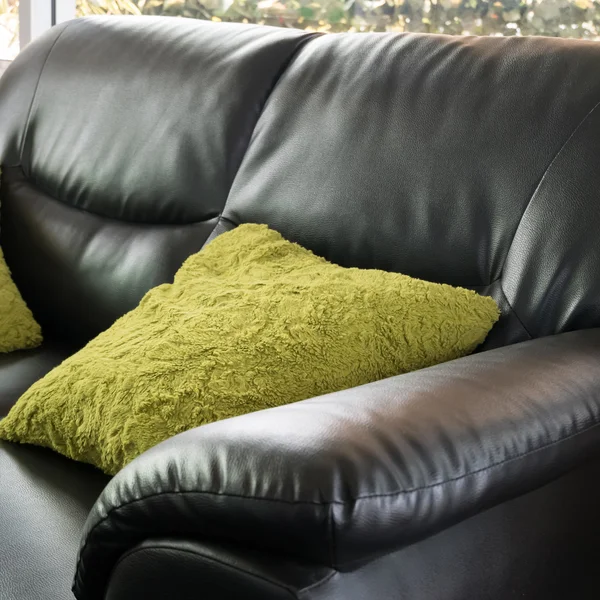 Czarny skórzany sofa meble z zielonej poduszki w salon — Zdjęcie stockowe