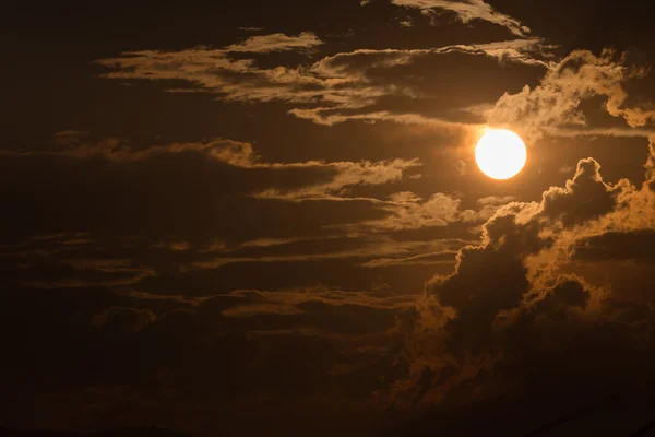 Cielo naranja con sol y nubes negras —  Fotos de Stock