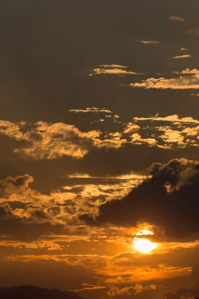 Оранжевое небо с солнцем и черными облаками — стоковое фото