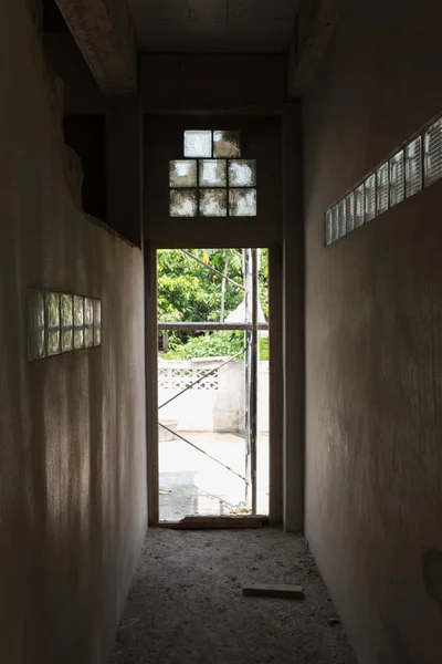 Chambre vide mur de ciment abandonné avec sortie de porte en construction — Photo