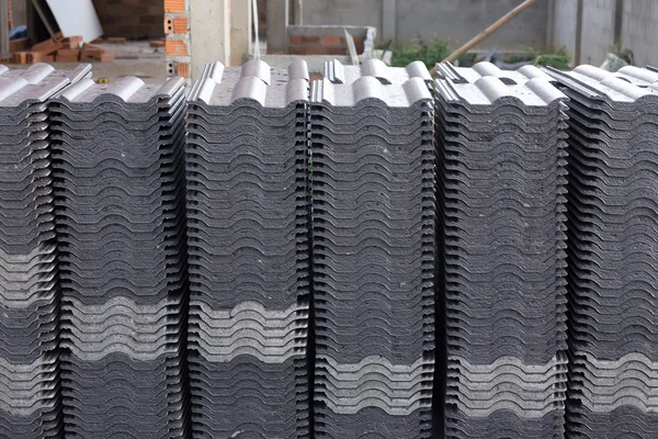 Pila de tejas negras en el sitio de construcción — Foto de Stock