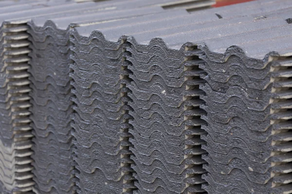 Stack of black roof tiles in construction site — Stock Photo, Image