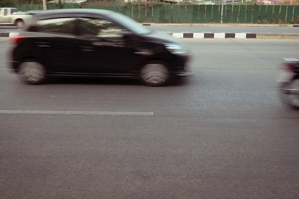 Быстро размытое движение автомобиля по дороге — стоковое фото