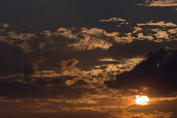 Himmel bei Sonnenuntergang mit Sonne und schwarzen Wolken — Stockfoto