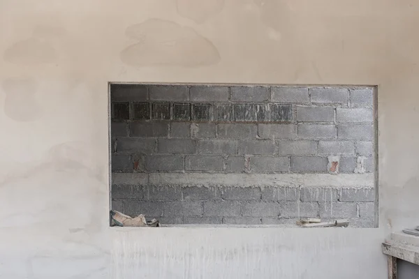 Fenêtre sur mur de ciment avec fond de mur de brique dans la construction — Photo