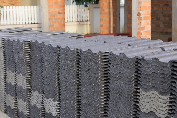 Stack of black roof tiles in construction site — Stock Photo, Image