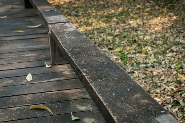 Antigua pasarela de madera con hojas que caen en la mañana del otoño — Foto de Stock