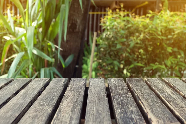 Old table wood plank with green natural blurred background — Stock Photo, Image