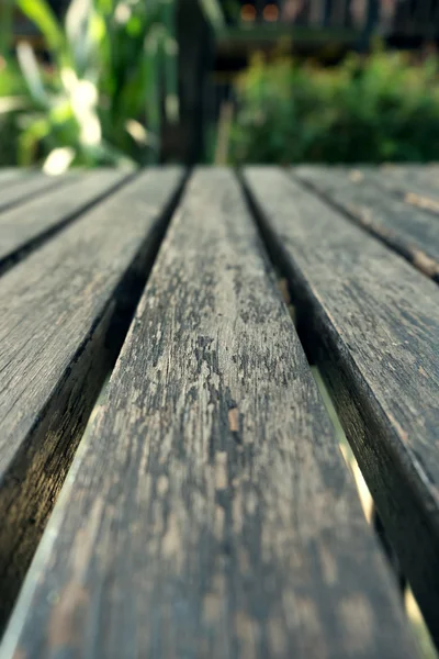 Tablón de madera de mesa vieja con fondo borroso natural verde — Foto de Stock