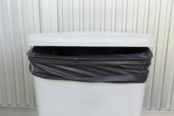 Black bag plastic in white trashcan bin — Stock Photo, Image