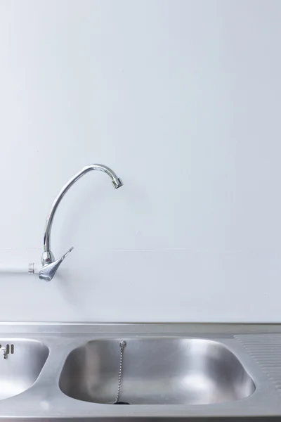 Évier et robinet en acier inoxydable dans la salle de cuisine blanche — Photo