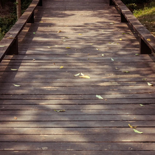 가 아침에 떨어지는 나뭇잎과 오래 된 목조 산책로 — 스톡 사진