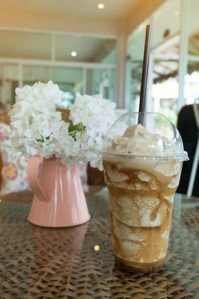 Café frappe helado en taza de plástico poner en la mesa de tejido de ratán —  Fotos de Stock