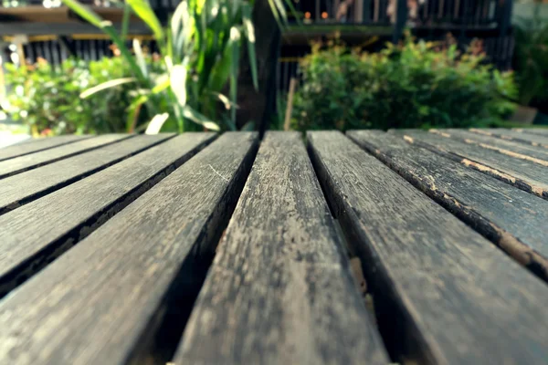 Tábua de madeira de mesa velha com fundo desfocado natural verde — Fotografia de Stock
