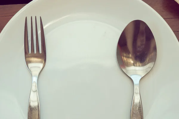 Louça conjunto na mesa de madeira com prato, colher e garfo — Fotografia de Stock