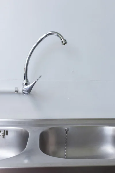 Évier et robinet en acier inoxydable dans la salle de cuisine blanche — Photo