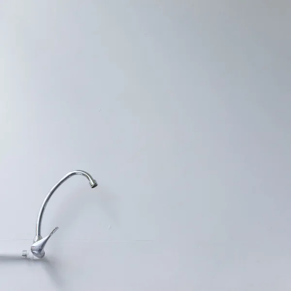 Wasserhahn aus Edelstahl auf weißem Mörtel Wandhintergrund — Stockfoto