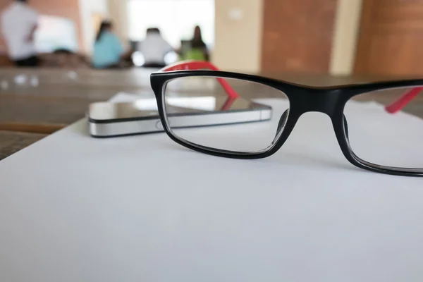 Óculos colocados em uma folha de papel em branco — Fotografia de Stock