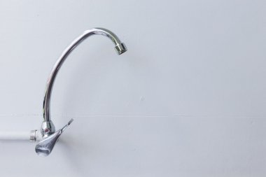 musluk paslanmaz çelik beyaz harç duvar arka plan üzerinde