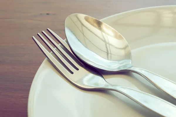 Dishware set on wood table with plate, spoon and fork — Stock Photo, Image