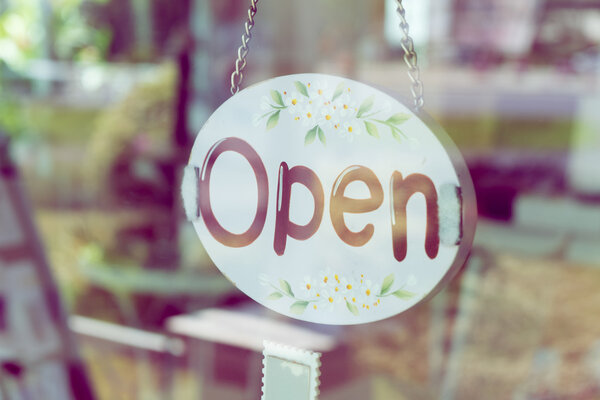 open sign broad hanging on door mirror in coffee shop cafe