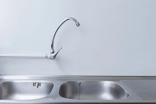 Évier et robinet en acier inoxydable dans la salle de cuisine blanche — Photo