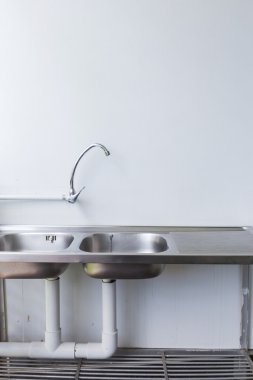 Paslanmaz çelik lavabo ve musluk beyaz mutfak oda içinde