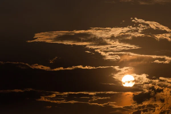 Orangefarbener Himmel mit Sonne und schwarzen Wolken — Stockfoto