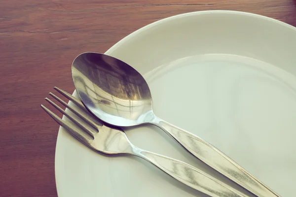 Dishware set on wood table with plate, spoon and fork — Stock Photo, Image