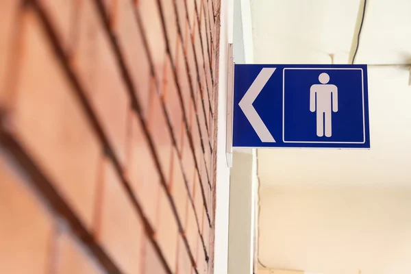 Sinais de banheiro com símbolo masculino e sinais de direção de seta — Fotografia de Stock