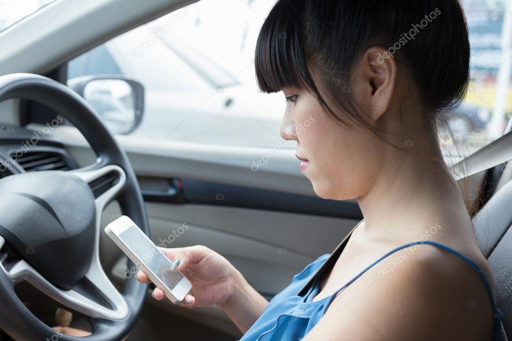 woman using a smart phone in car